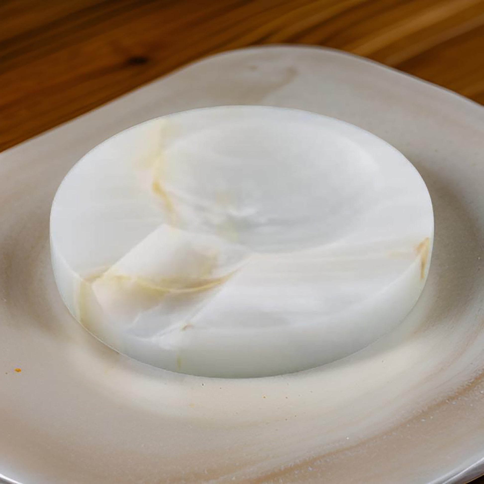 Onyx spoon rest placed on a ceramic plate with warm lighting