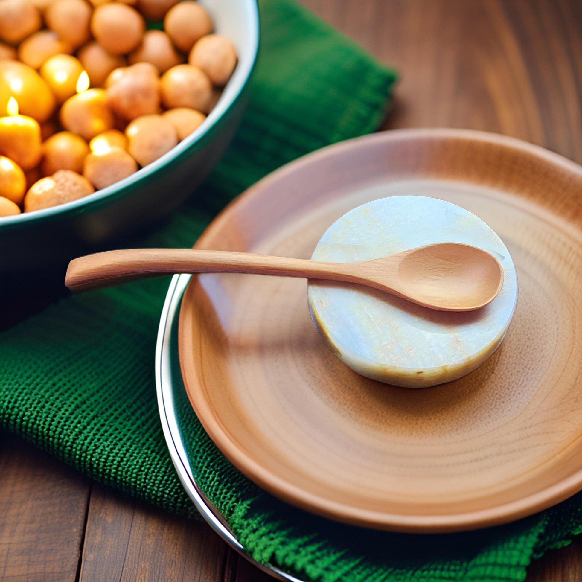Onyx spoon rest with wooden spoon beside a bowl of treats and candles