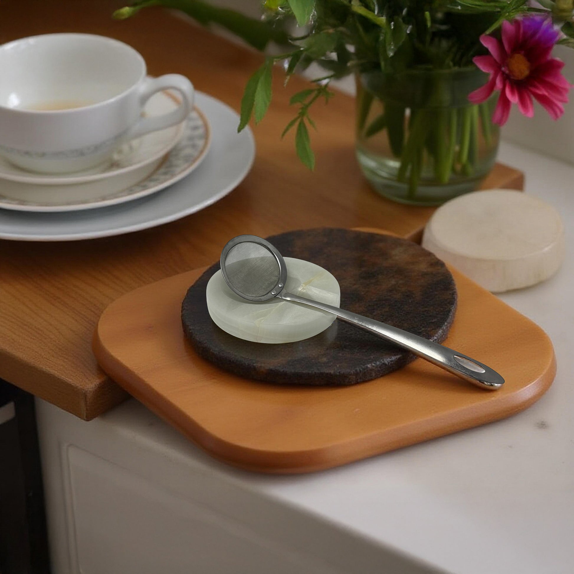 Onyx spoon rest used with a tea strainer, next to a flower vase